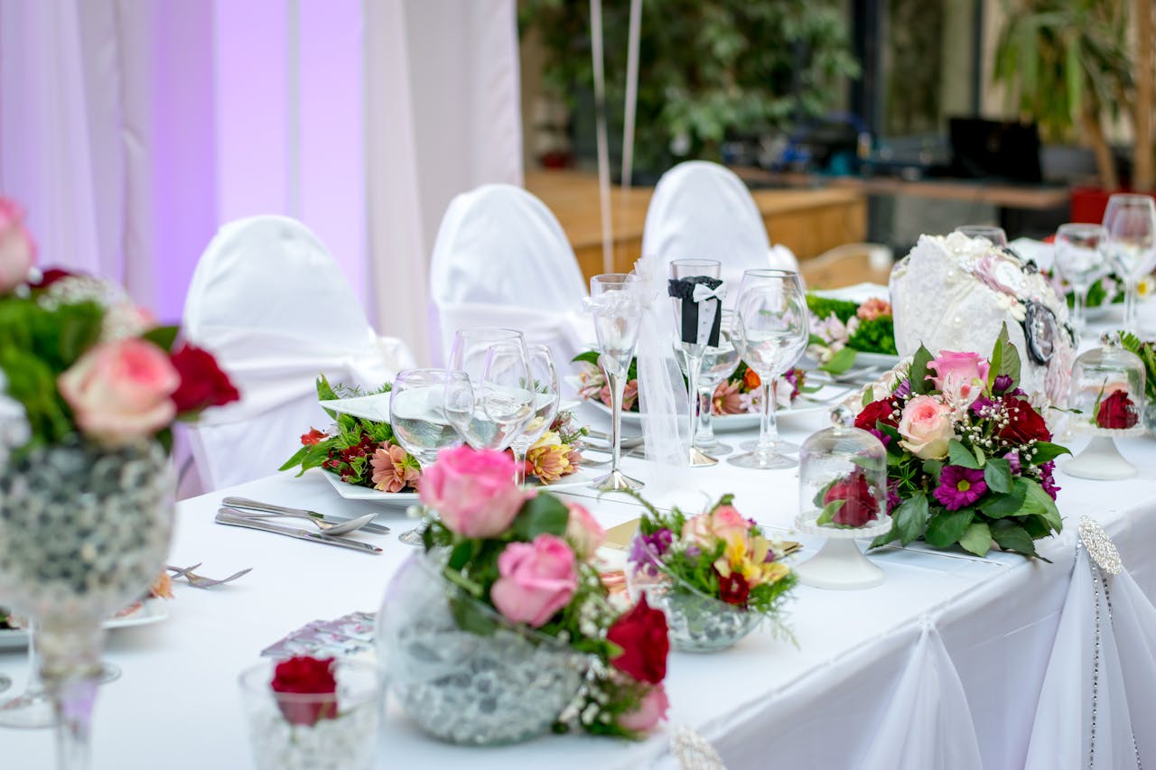 about-us Beautifully decorated wedding table setting with floral arrangements and wine glasses, creating an elegant atmosphere.